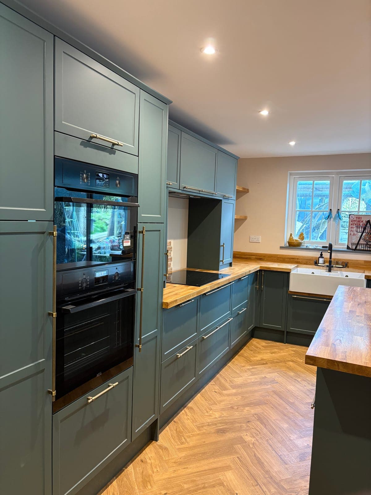 Modern fitted kitchen with green units in a St Austell home, Cornwall
