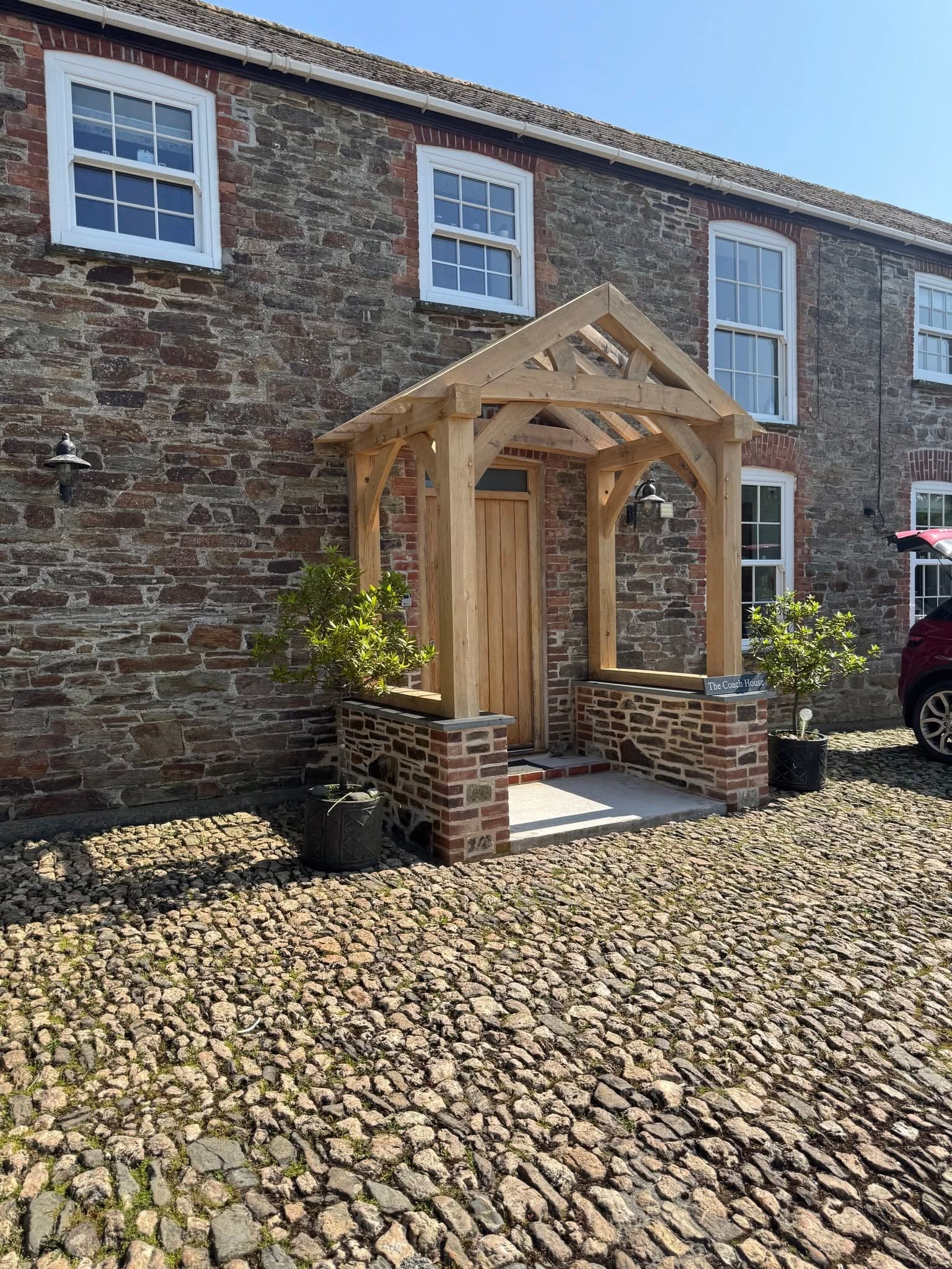 Bespoke oak-framed porch extension on a traditional stone cottage in Cornwall